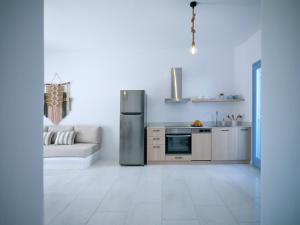 una cucina con frigorifero in acciaio inox e divano di Etherio Apartment II a Piso Livadi
