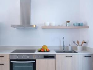 una cucina con lavandino e cesto di frutta di Etherio Apartment II a Piso Livadi