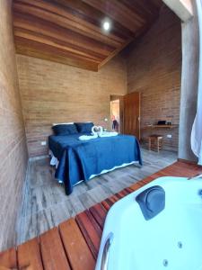 a bedroom with a blue bed in a room at Recanto da Pedra Chalé in São Bento do Sapucaí