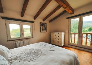 een slaapkamer met een groot wit bed en ramen bij Casa de Campo La Solana in Estollo