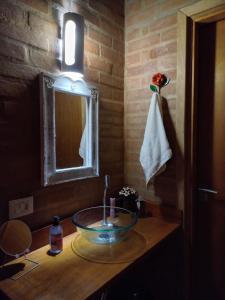 uma casa de banho com um lavatório e um espelho em Recanto da Pedra Chalé em São Bento do Sapucaí