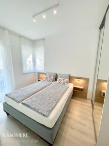 1 dormitorio con 1 cama con 2 almohadas en CASHMERE Premium Apartment, en Siófok