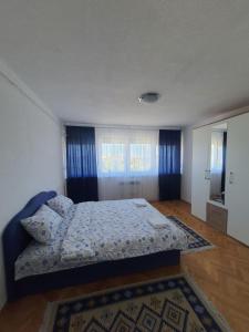 um quarto com uma cama com um edredão azul em Apartman Nataša BL em Banja Luka