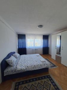 a bedroom with a bed with a blue comforter at Apartman Nataša BL in Banja Luka
