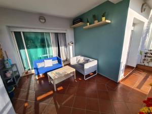 salon z niebieską ścianą i kanapą w obiekcie Spacieux appartement dans une résidence avec piscine w mieście Al-Muhammadijja