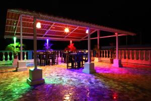 a night view of a patio with tables and lights at Baga Fantacia Beach Inn in Baga