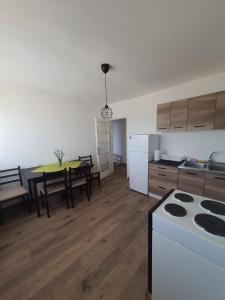 uma cozinha e sala de estar com uma mesa e um fogão em Apartman Nataša BL em Banja Luka