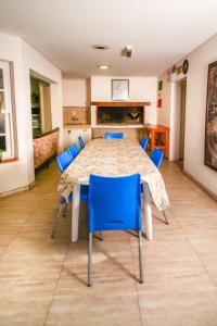 a dining room with a table and blue chairs at Jaque Mate Hostel in Mendoza