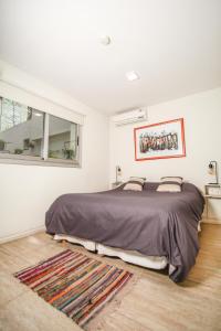 Un dormitorio con una cama grande y una ventana en Jaque Mate Hostel en Mendoza
