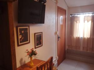 a living room with a vase of flowers on a table at Pousada Caminhos de Minas Belo Horizonte in Belo Horizonte