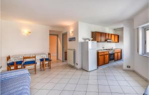 a small kitchen with a table and a refrigerator at Amazing Home In Spotorno With Wifi in Spotorno