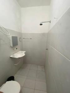 La salle de bains blanche est pourvue de toilettes et d'un lavabo. dans l'établissement Lotus Flat - Canoa Quebrada, à Aracati