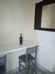 un tavolo con una bottiglia di vino e due sedie di Agriturismo Il Principino a Vinci
