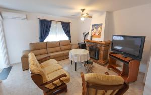 uma sala de estar com um sofá e uma televisão em casa familiar La Lunara em Cáceres