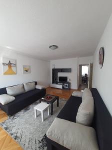 uma sala de estar com um sofá e uma mesa em Apartman Nataša BL em Banja Luka