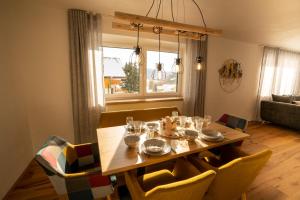 comedor con mesa, sillas y ventana en Bergzauber Appartements, en Rennweg