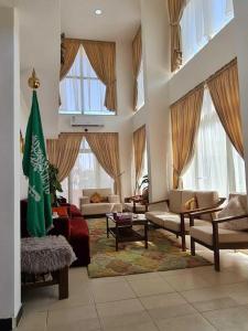un soggiorno con divani e bandiera di دار اوتيل Dar Otel a Arar
