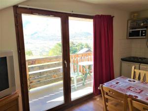 d'une cuisine avec une porte coulissante en verre s'ouvrant sur un balcon. dans l'établissement Appartement La Joue du Loup, 2 pièces, 6 personnes - FR-1-504-470, à Saint-Étienne-en-Dévoluy