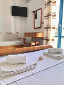 a room with towels on the floor and a mirror at Traditional Concept Apartments Placidity in Aliki