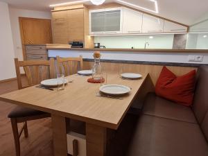 una mesa de madera con platos en la cocina en Appartement Gsaller en Hopfgarten in Defereggen