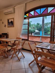a room with tables and chairs and a large window at Pousada Bella Vista in Gravatal