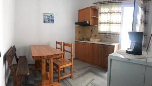 a kitchen with a wooden table and a table and chairs at Traditional Concept Apartments Placidity in Aliki
