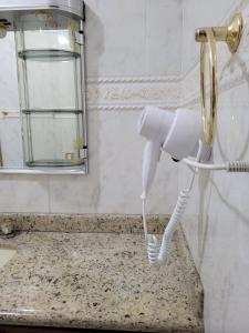 a white phone in a bathroom with a mirror at Pousada Bella Vista in Gravatal +17 photos