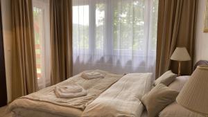 ein Bett mit zwei Handtüchern darauf vor einem Fenster in der Unterkunft Villa K2 in Karpacz