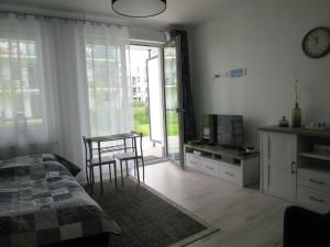a bedroom with a bed and a table and a television at Studio Verdemar Nexo in Puck