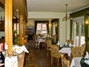 Haus Waldesruh في Petersdorf: غرفة طعام مع طاولات وكراسي في مطعم