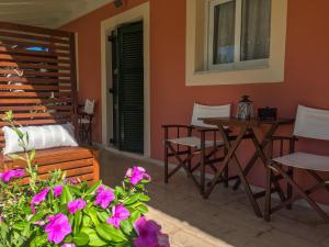 a living room with a table and chairs and flowers at Nikodimos Garden Studios in Agios Georgios
