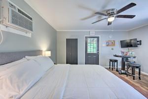 1 dormitorio con 1 cama blanca grande y ventilador de techo en Cozy Studio Cabin on Lake O the Pines with Deck!, en Avinger