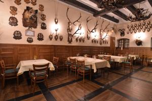 a dining room with tables and chairs and antlers on the wall at Resort Dworzysko in Szczawno-Zdrój