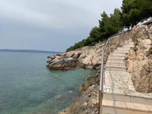 eine Treppe zum Wasser an einem felsigen Ufer in der Unterkunft Villa Nona Tamara with Astonishing Sea & Mountains View in Bribir
