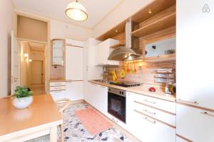 cocina con armarios blancos y mesa de madera en Appartamento Vacanze Taormina, en Taormina