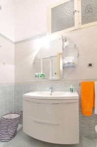 a bathroom with a white sink and a mirror at Appartamento Vacanze Taormina in Taormina