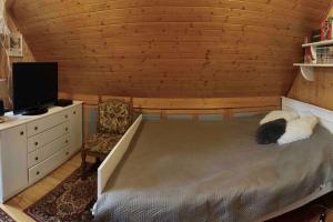1 dormitorio con 1 cama, TV y silla en Dom Rodzinny w Augustowie (przy ulicy Sajenek) en Augustów