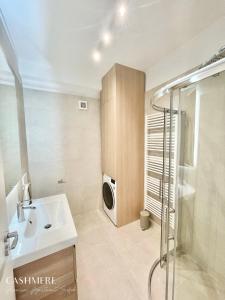 a bathroom with a sink and a washing machine at CASHMERE Premium Apartment in Siófok