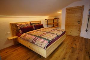 a bedroom with a bed and a wooden floor at Bergzauber Appartements in Rennweg