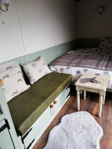 a bedroom with two twin beds and a table at Durham Donkey Rescue Shepherd's Hut in Durham