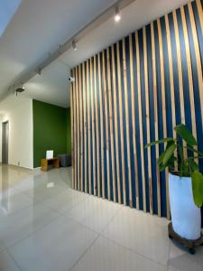 a lobby with a green wall and a potted plant at Ayenda 1224 Pixel House in Medellín