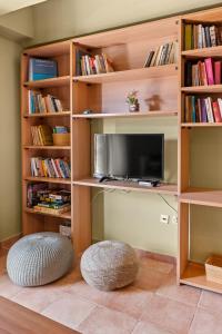 a book shelf with a tv and a ottoman at La Casetta in Argostoli