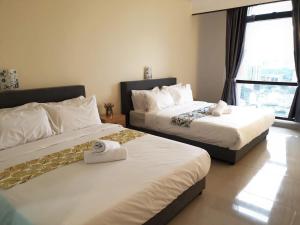 a hotel room with two beds and a window at KL Times Square Apartment in Kuala Lumpur