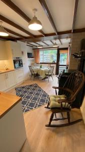 uma sala de estar com uma mesa e uma cadeira de baloiço em Cosy country cottage in Central Scotland em Buchlyvie