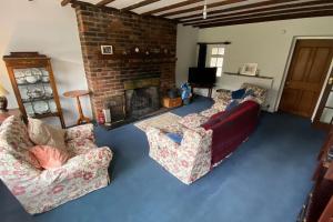 a living room with two couches and a fireplace at Cosy country cottage in Central Scotland in Buchlyvie