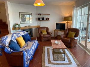 ルースにあるBlue Ocean Villaのリビングルーム(ソファ、椅子、テレビ付)
