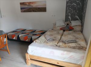 a bedroom with two twin beds and a picture on the wall at Csilla Apartman in Balogunyom