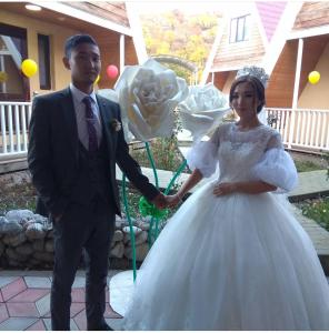 Ein Mann und eine Frau in einem weißen Hochzeitskleid. in der Unterkunft Kanym Guest Complex in Karakol