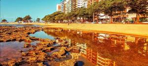 a view of a beach with a reflection in the water at Vem pra cá! Localização Privilegiada! in Guarapari