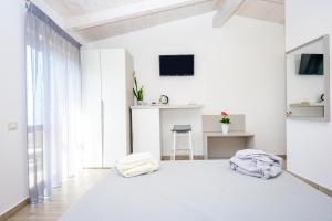 una camera bianca con un grande letto con asciugamani di Antica Dimora Palinuro a Palinuro